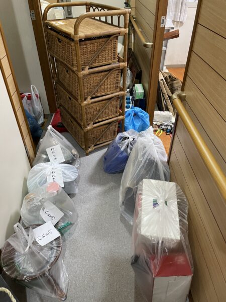 実家の片づけでで粗大ごみや分別ごみをビニール袋に入れて出す準備をしている写真